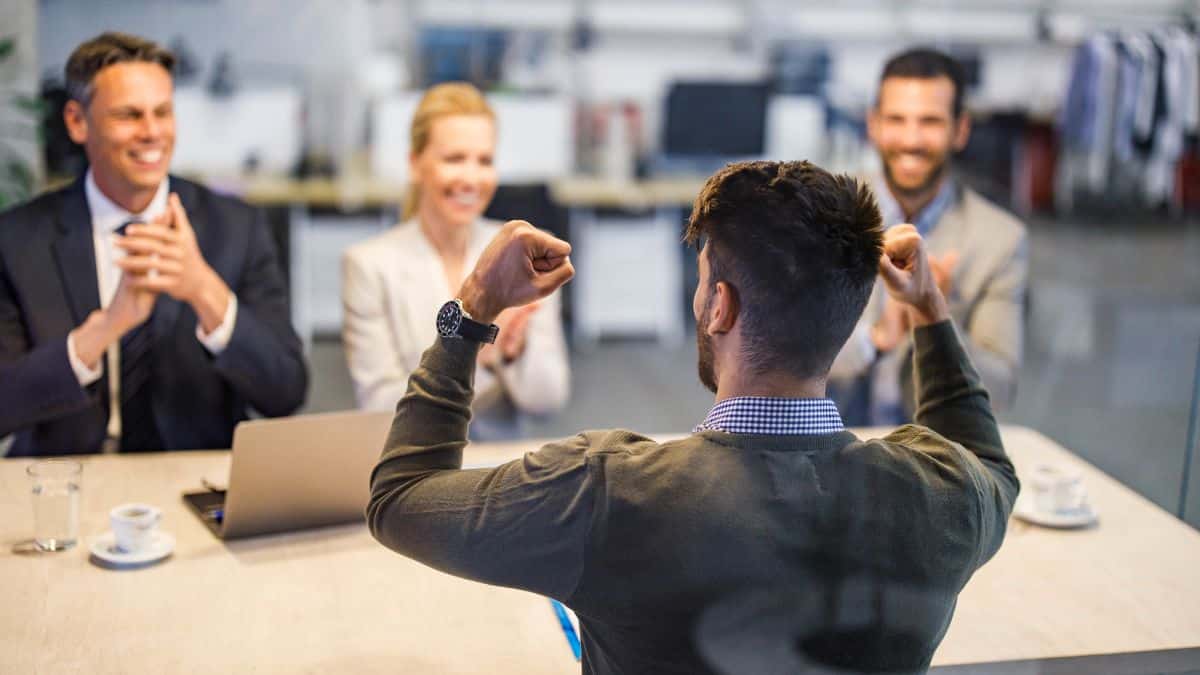 candidat souriant après un entretien d'embauche réussi avec un recruteur