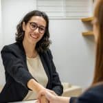 Entretien d'alternance : comment le réussir (guide complet) Recruteuse souriante serrant la main d'une candidate lors d'un entretien alternance