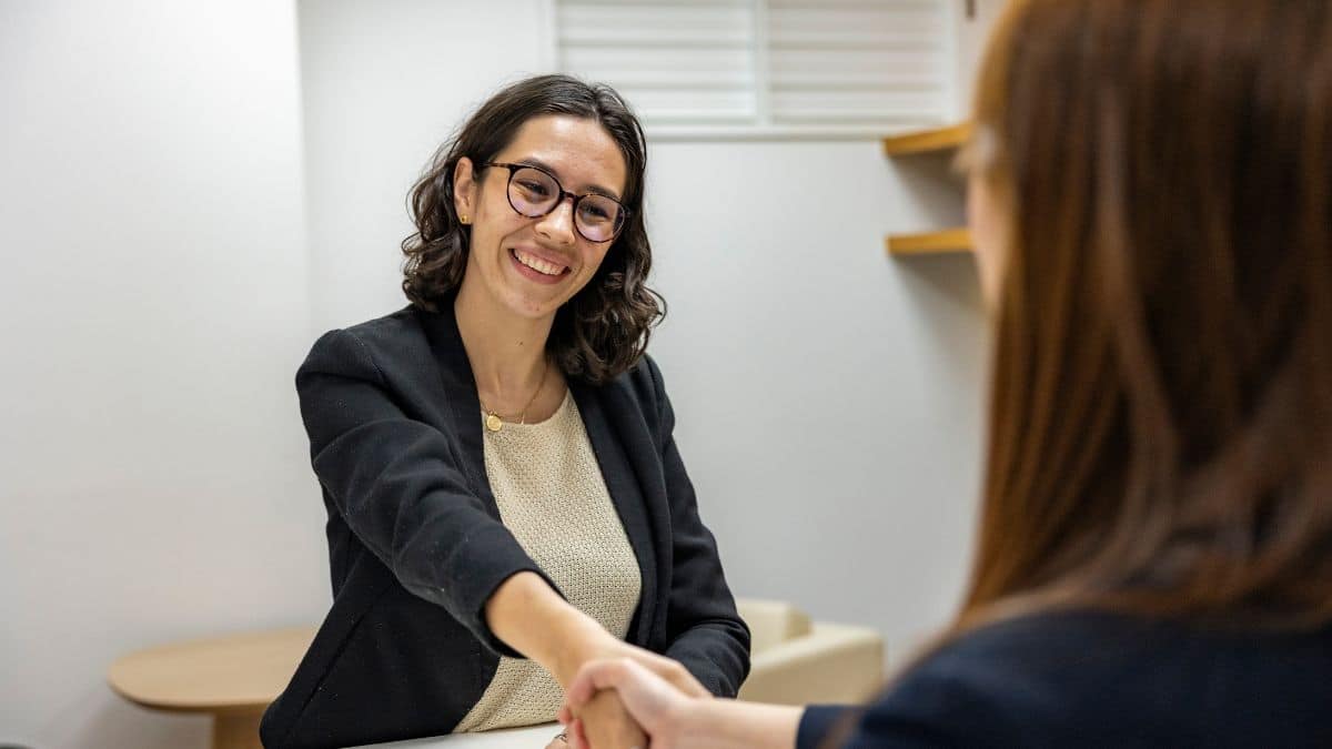 Recruteuse souriante serrant la main d'une candidate lors d'un entretien alternance