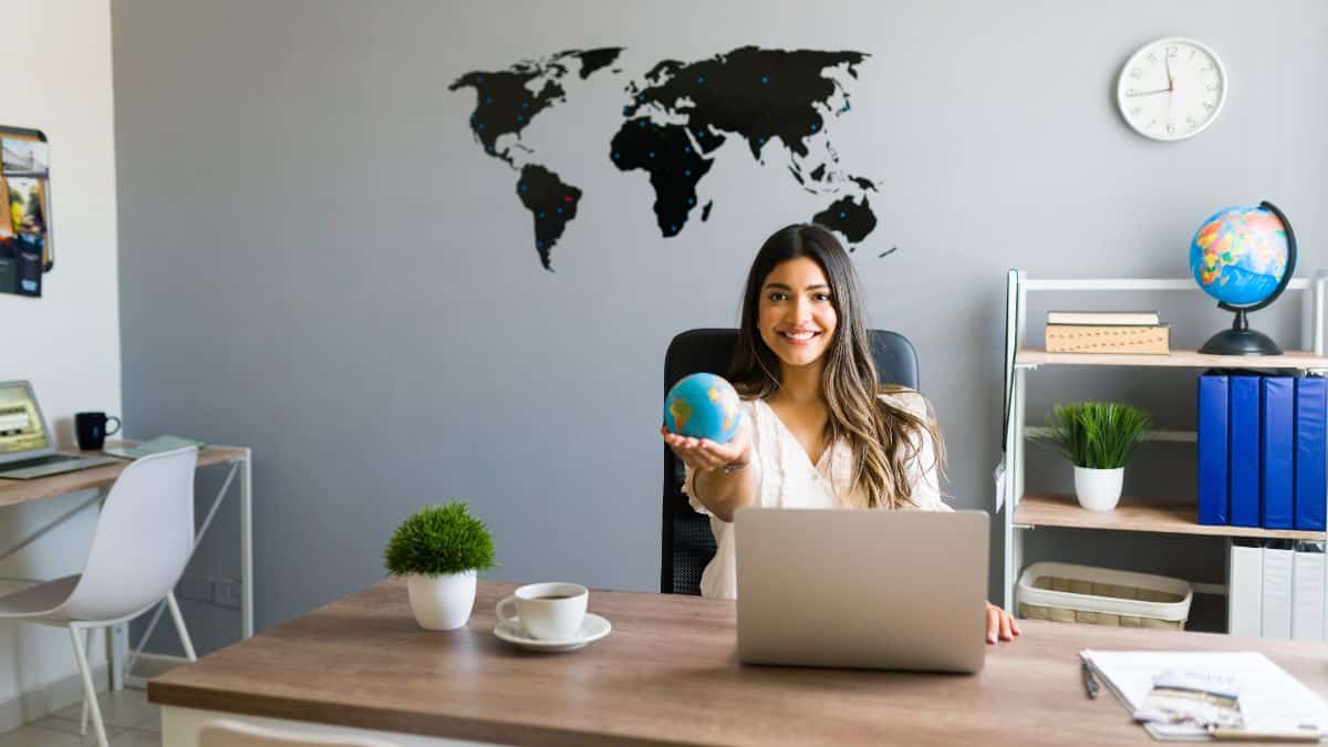 Femme souriante en entretien cabinet de recrutement assise à son bureau avec un ordinateur portable